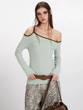 Close-up of a model showcasing the asymmetrical neckline and contrast trim of a light green ribbed knit top.