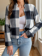 Woman wearing a blue and white plaid cropped jacket with an open front.