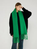 Woman modeling a bright green brushed wool blend scarf with fringe trim.