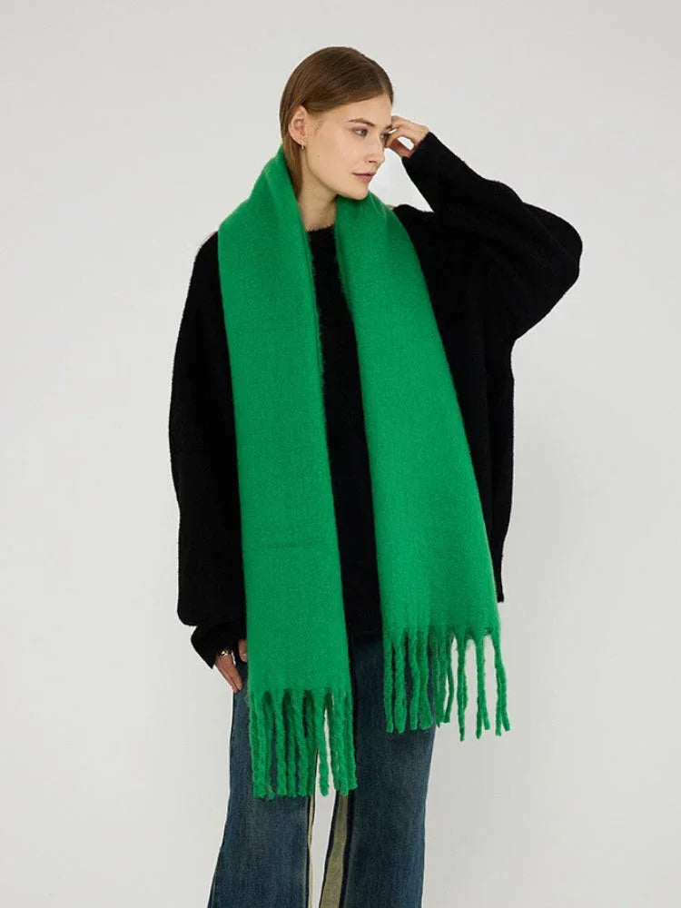 Woman modeling a bright green brushed wool blend scarf with fringe trim.