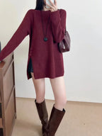 Close-up of a burgundy knit tunic with ribbed texture and button accents.