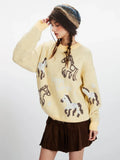 Side view of a woman wearing a yellow knit sweater with a horse graphic print, brown pleated skirt, white socks, and brown boots.