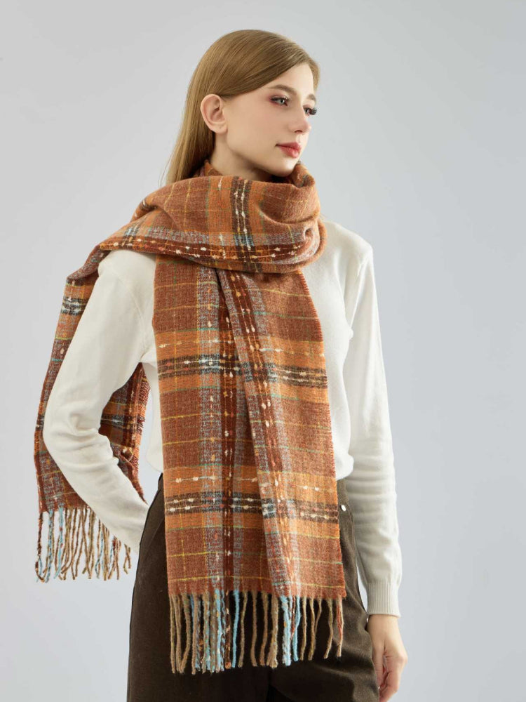 Woman wearing an orange tartan plaid scarf with fringe