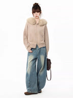 Full body shot of a woman in a faux fur collar knit cardigan and wide-leg jeans