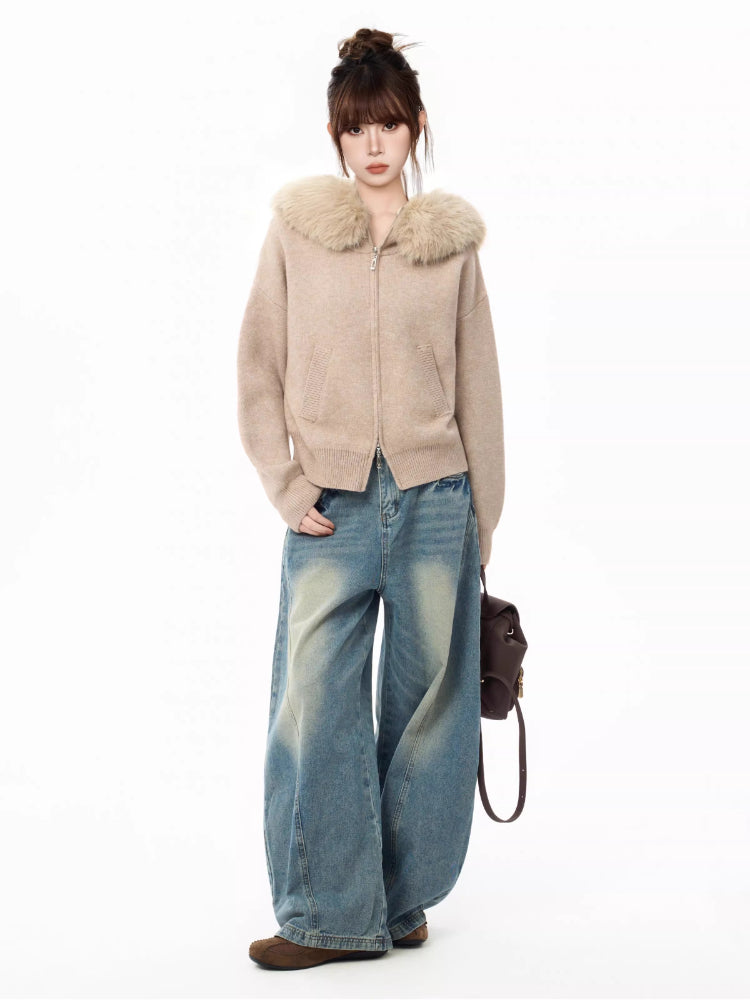 Full body shot of a woman in a faux fur collar knit cardigan and wide-leg jeans