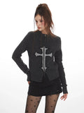 Woman posing in a dark grey knit zip-up cardigan featuring a cross graphic.