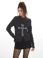Woman posing in a dark grey knit zip-up cardigan featuring a cross graphic.