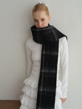 fashionable woman accessorizing with a plaid scarf