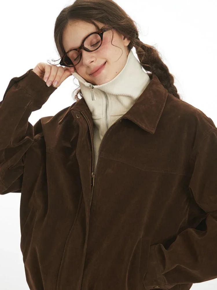 Close-up of the collar and neckline of a brown corduroy bomber jacket worn by a woman.