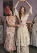 Mannequin displaying a cream-colored garment with blue floral embroidery.