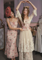 Mannequin displaying a cream-colored garment with blue floral embroidery.