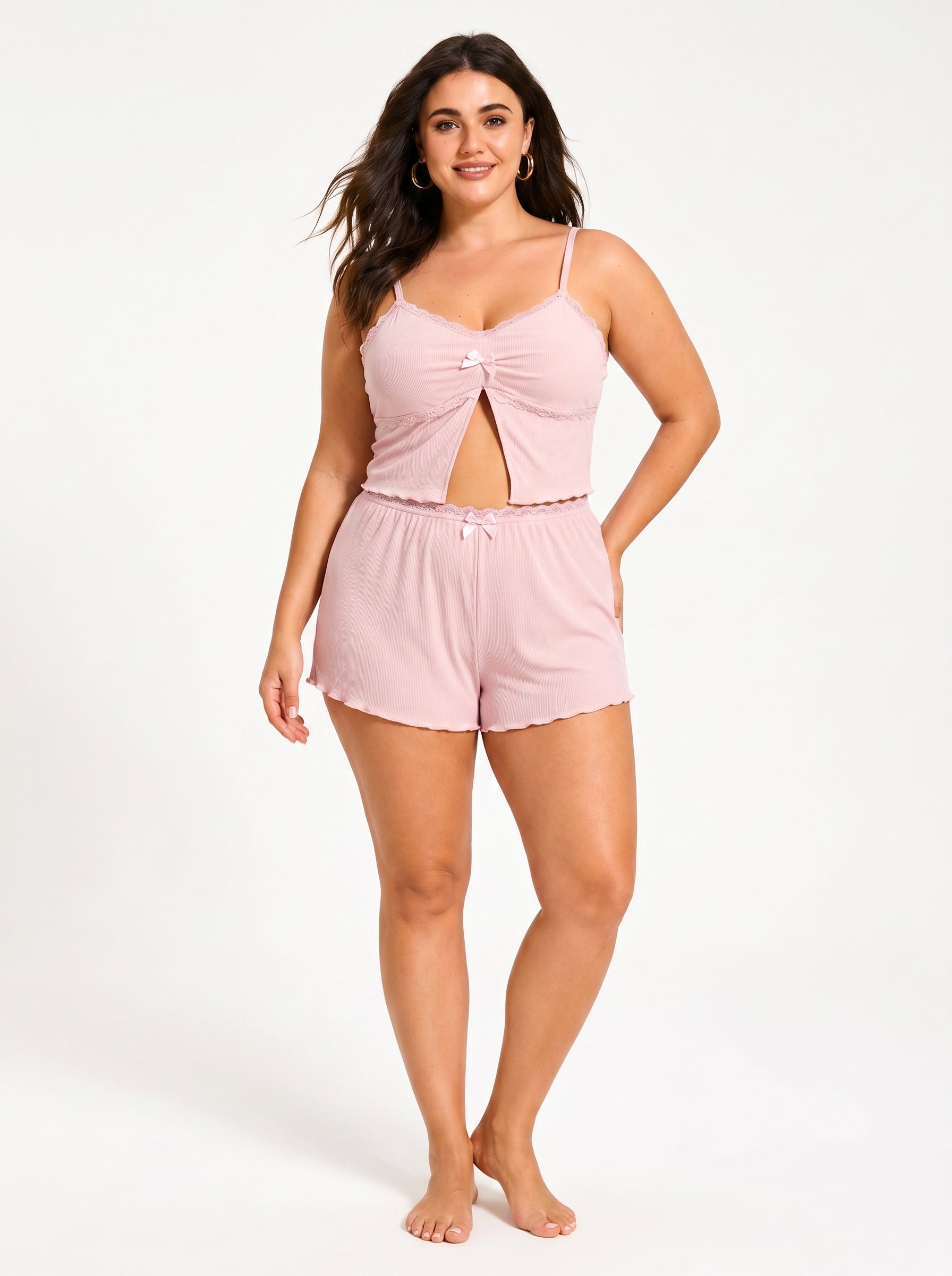 Woman standing with a hand on her hip, wearing a pink pajama set