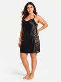 Woman wearing a black satin slip dress with lace insets and hand on hip from the side.
