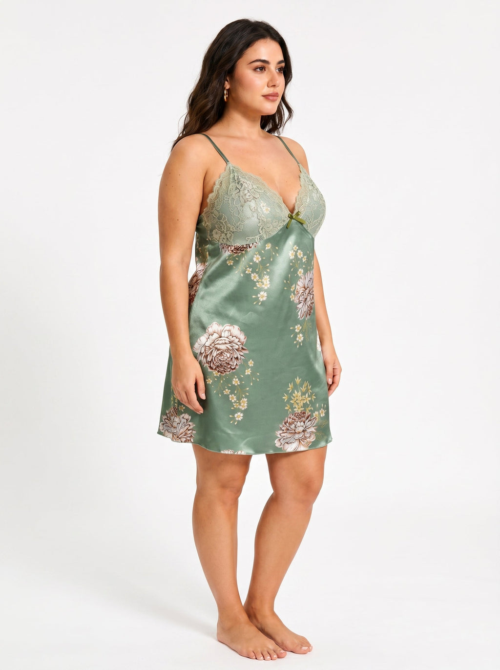 Side view of a woman wearing a green satin slip dress with floral print