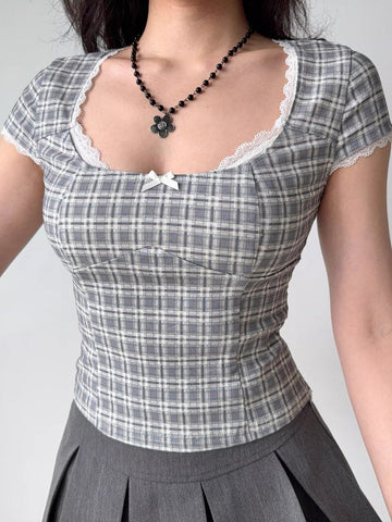 Grey plaid fitted short sleeve top with white lace trim and a small white bow detail at the neckline.