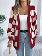 Full body shot of a woman wearing a red and cream checkerboard knit cardigan.