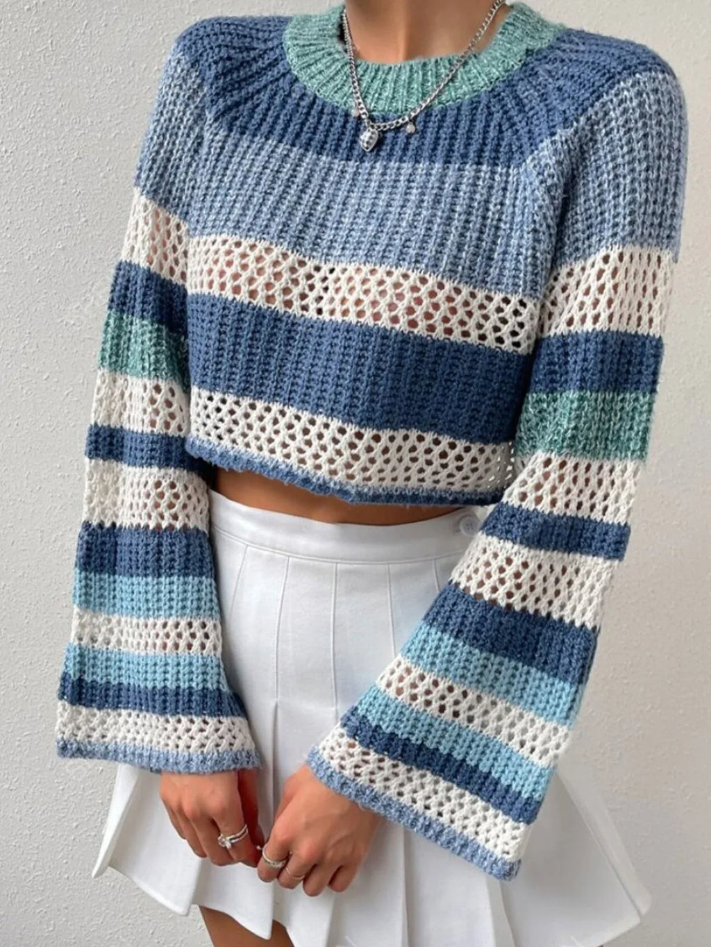 Close-up of the striped pattern and crochet detail on a blue, white, and green knit cropped sweater.