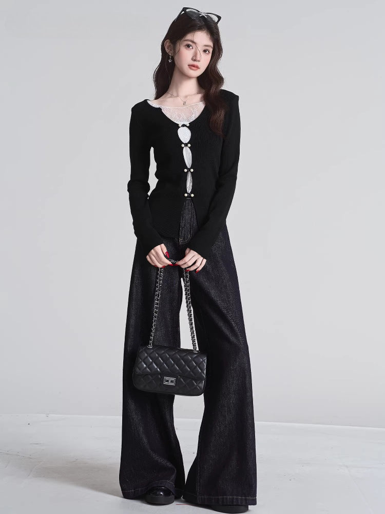 Full body shot of a woman in a black knit top and wide-leg jeans