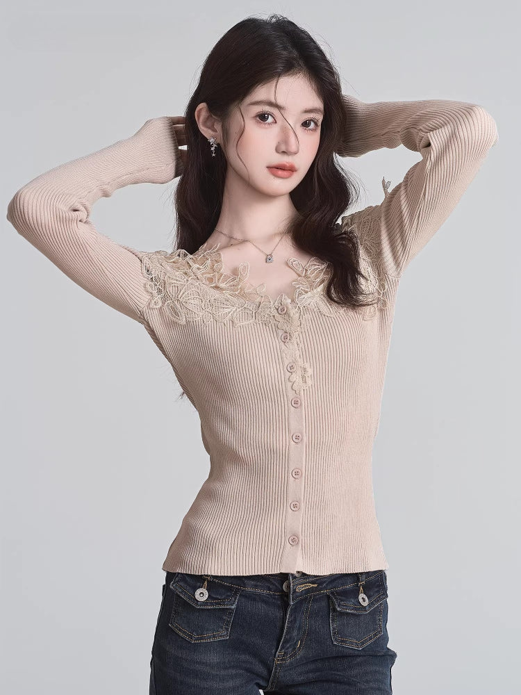 Woman wearing a beige fitted ribbed knit cardigan with lace trim and button-down front, adjusting her hair