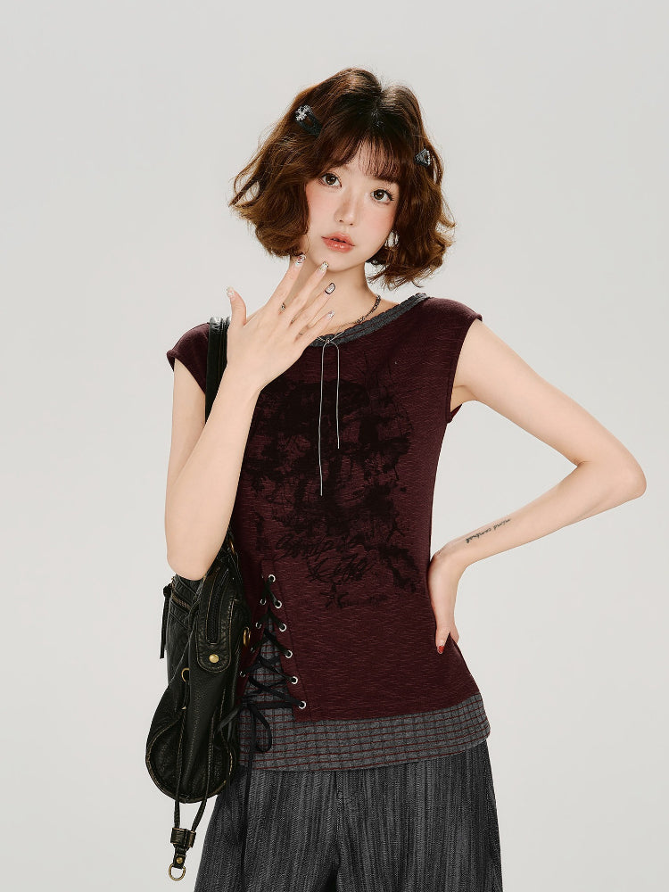 Model wearing a burgundy cap sleeve top with a boat neckline and lace-up side detail.