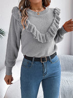 Woman posing in a gray ruffle trim crew neck sweater