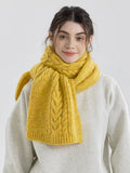Woman wearing a yellow cable knit scarf