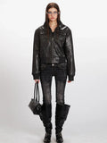 Woman wearing a black faux leather bomber jacket with zipper closure and chest pockets, black jeans, and black boots.