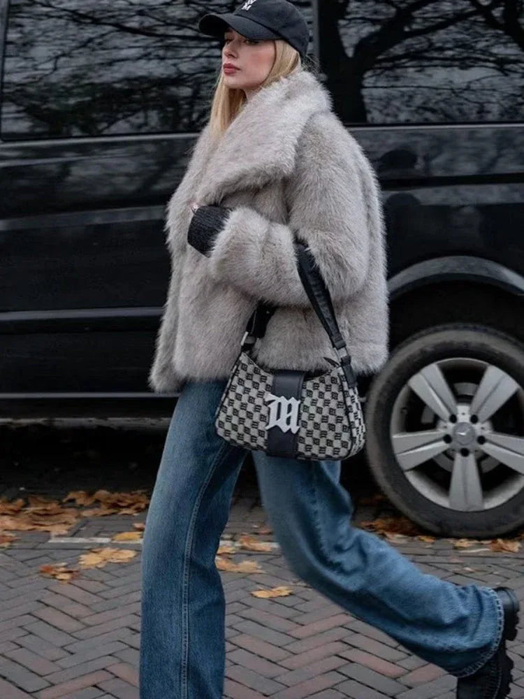 woman wearing a light grey faux fur jacket with a wide collar and black baseball cap
