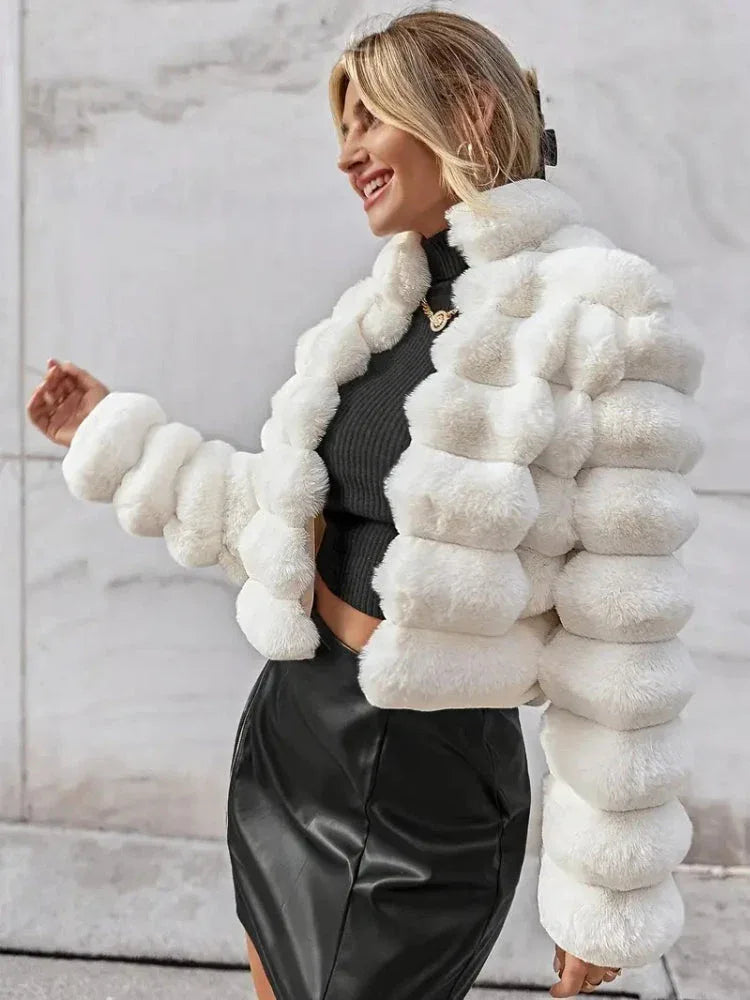 Woman wearing a white faux fur jacket with horizontal ribbed texture