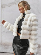 Woman wearing a white faux fur jacket with horizontal ribbed texture