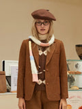 Woman wearing a brown textured wool blend blazer with a white turtleneck and a patterned sweater.