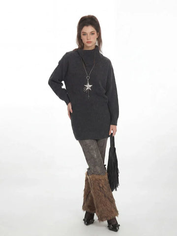 Woman wearing a charcoal grey knit tunic sweater with a high turtleneck and long sleeves.