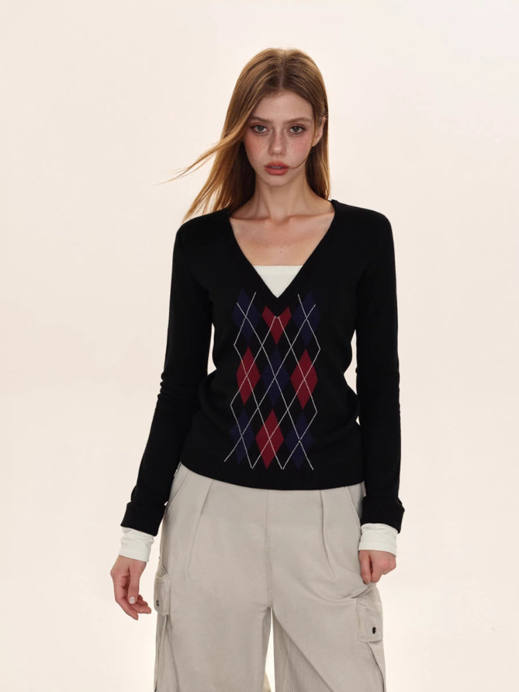Full body shot of a woman in a black argyle sweater and beige cargo pants.