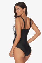 Rear view of a woman in a black and white striped one-piece swimsuit