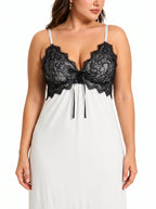 Front view of a woman wearing a white robe with black lace trim over a white slip dress