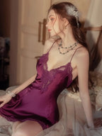 Close-up of a woman in a purple satin babydoll with lace neckline, seated indoors.