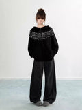 Back view of a woman wearing a black Fair Isle knit hoodie
