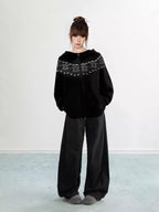 Back view of a woman wearing a black Fair Isle knit hoodie