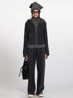 Woman wearing a charcoal grey zip-up hooded fleece jacket with a striped turtleneck and matching sweatpants.