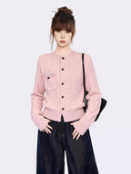 Front view of a pink cable knit cardigan with button closure