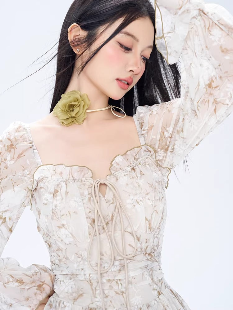 Woman wearing a white off-the-shoulder mini dress with a delicate floral print and long bishop sleeves.