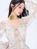 Close-up of a woman in a floral print mini dress, showcasing the tie-front detail and ruffled neckline.