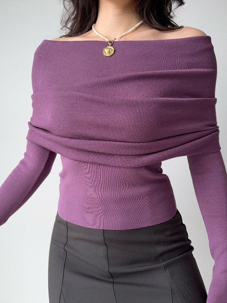 Woman wearing a purple off-the-shoulder ribbed knit top with long sleeves.