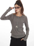 Woman adjusting glasses while wearing a grey faux layered henley top