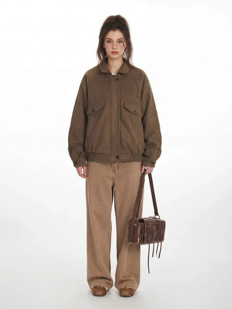 Woman wearing a brown textured bomber jacket with a collared neckline and button closure. Main image