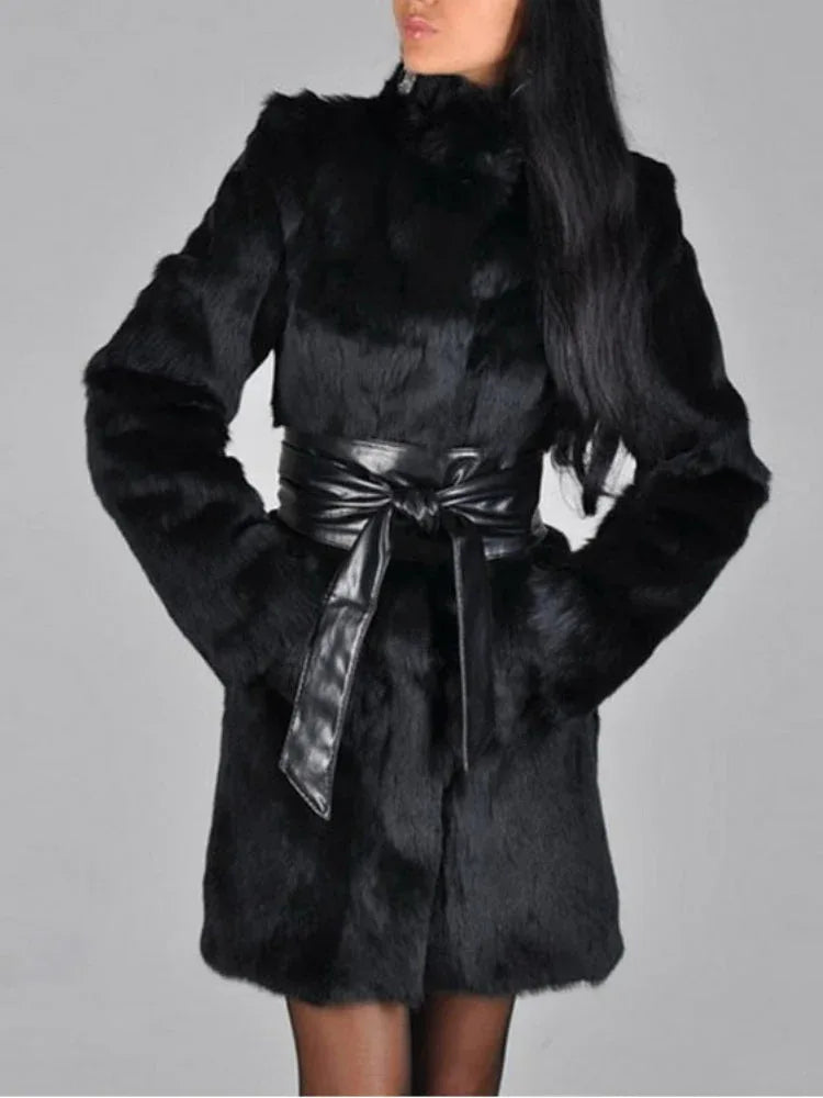 Woman wearing a black faux fur coat with a black leather belt, front three-quarter view