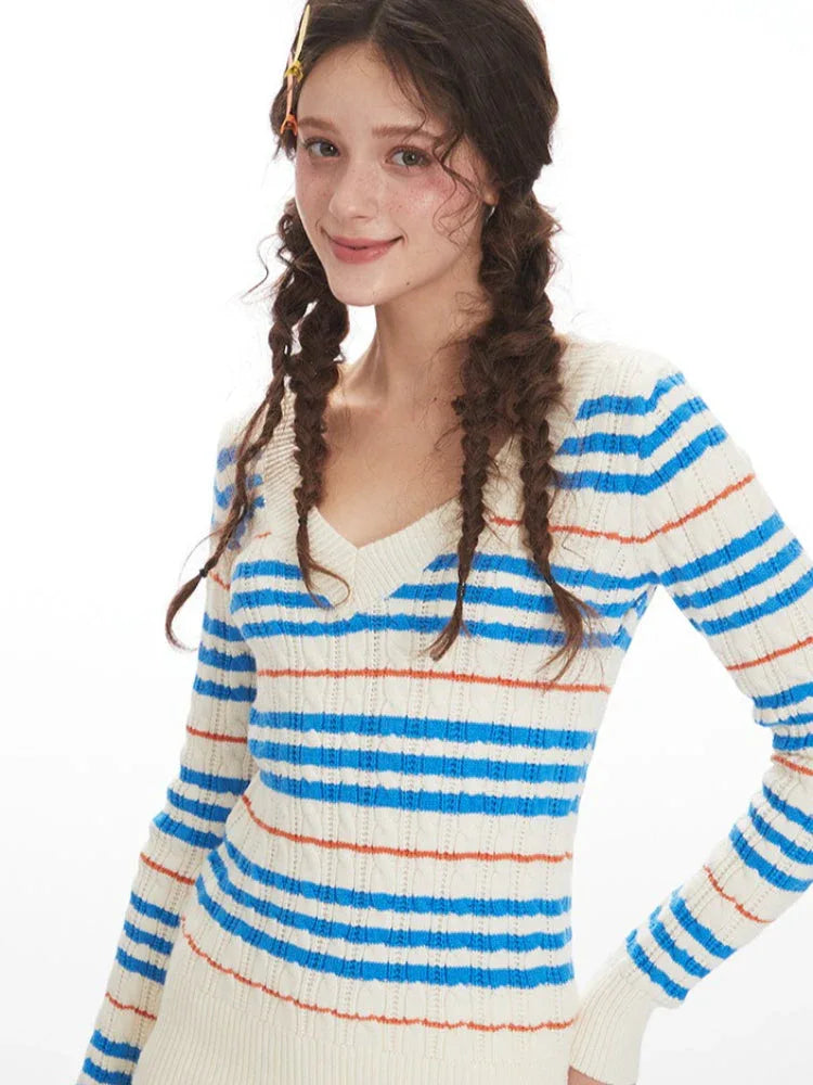 Detail of the v-neckline and striped pattern on a knit sweater.