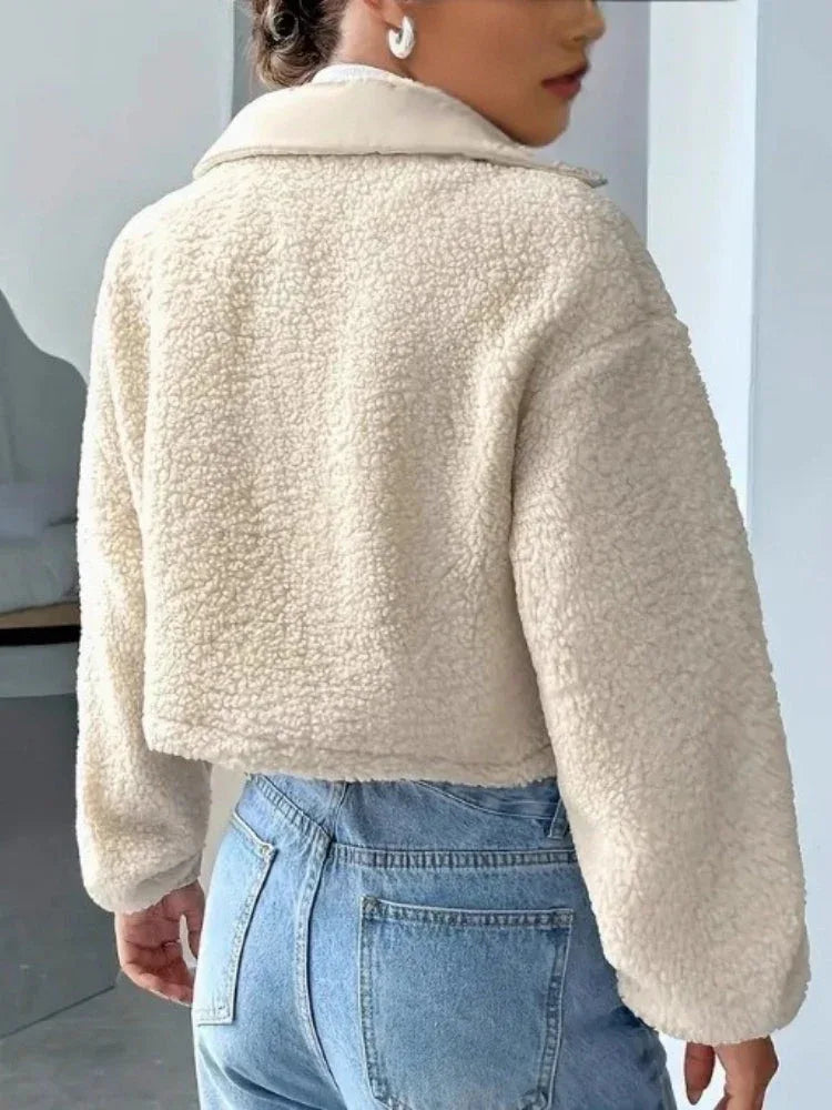 Back view of a cream sherpa fleece cropped jacket with a stand collar.
