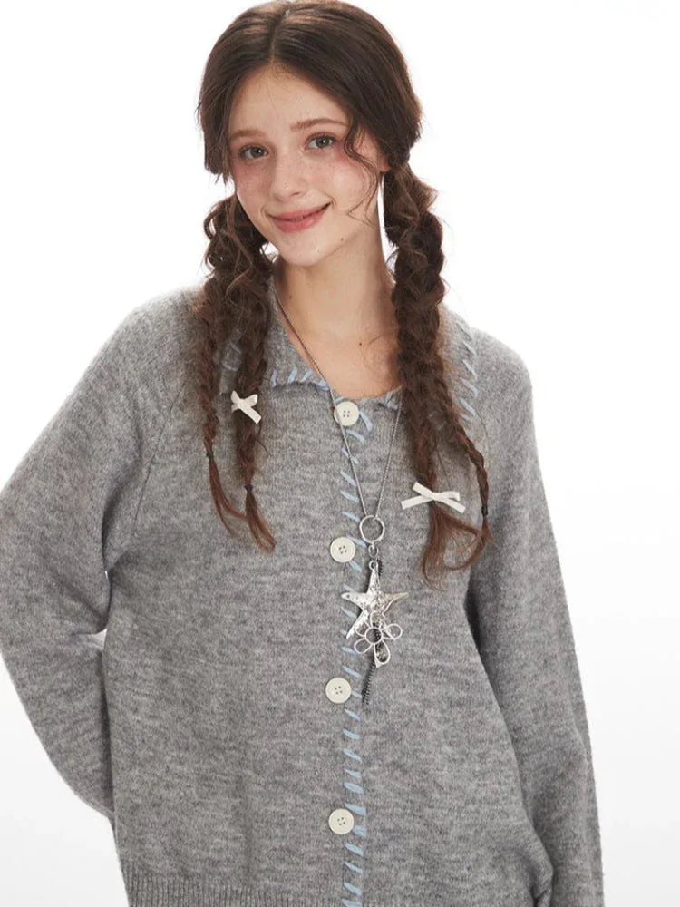 Front detail of a grey knitted cardigan showing buttons and neckline