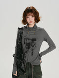 Close-up of the grey long-sleeve graphic print turtleneck top showcasing button detail